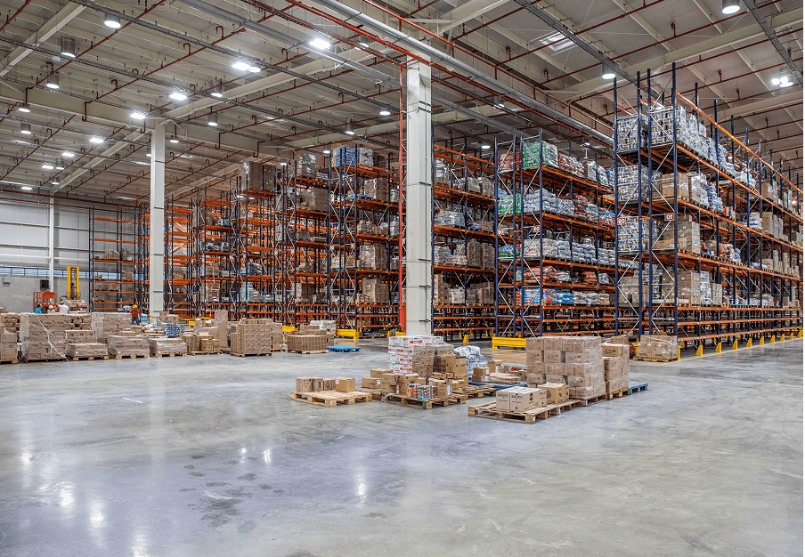Almacén logístico en Colombia con estanterías de almacenamiento y productos listos para distribuir, soluciones Dinova.