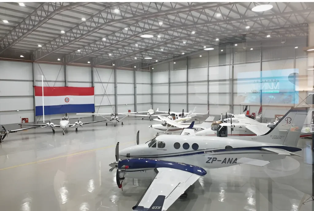 Nave hangar de aviación en Ciudad del Este, Paraguay, con aeronaves estacionadas. Estructura metálica diseñada y suministrada por Dinova.